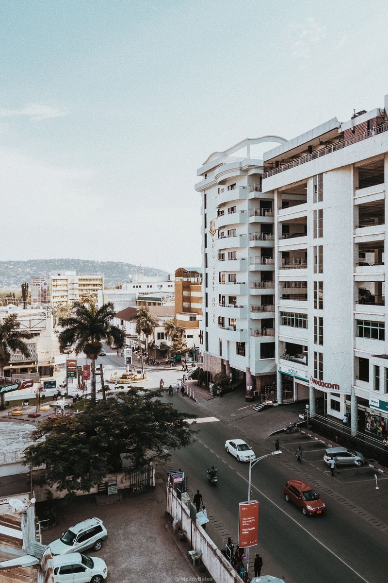 A bustling urban scene featuring modern buildings and a busy street during the day.